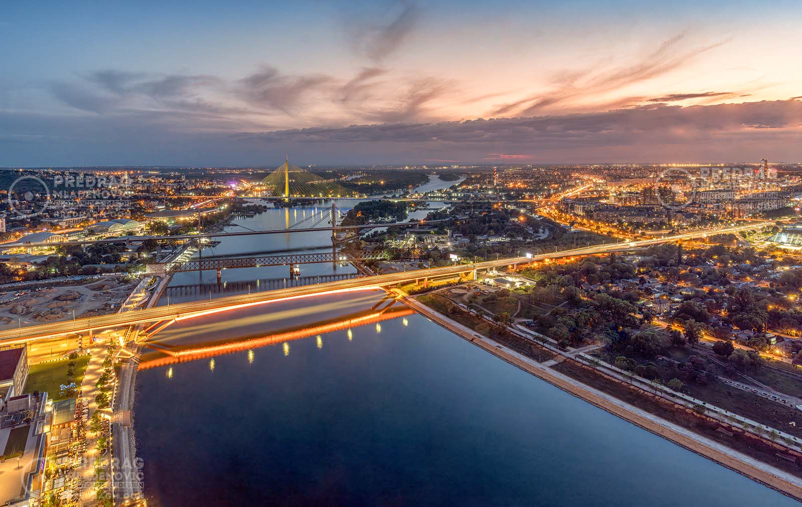 Široka panorama savskih mostova u suton